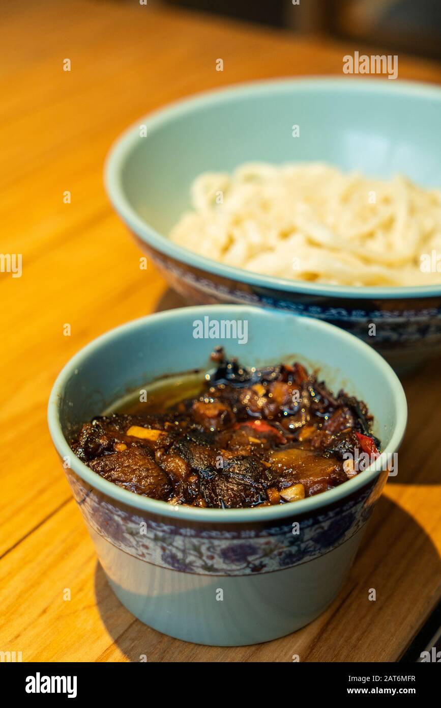 Chinesische Nudeln mit Aubergsauce auf dem Tisch Stockfoto