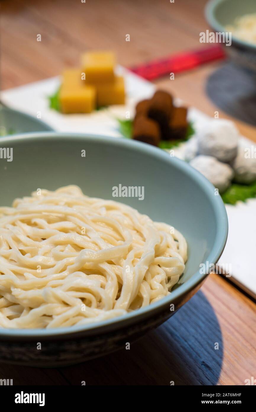 Chinesische Nudeln mit Pekinger traditionellem Gebäck, wie gelbes Pea-Gelee, rollender Esel (glutinöse Reisrollen mit süßem Bohnenmehl) auf dem Tisch Stockfoto