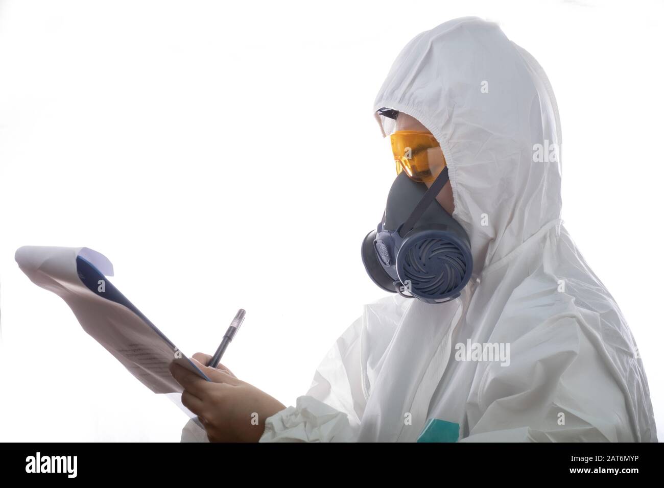 Frau in einer chemischen Schutzkleidung und Gasmaske mit Brille am weißen Hintergrund, Wissenschaftlerin im Schutzanzug, Sicherheitsvirusinfektion Stockfoto