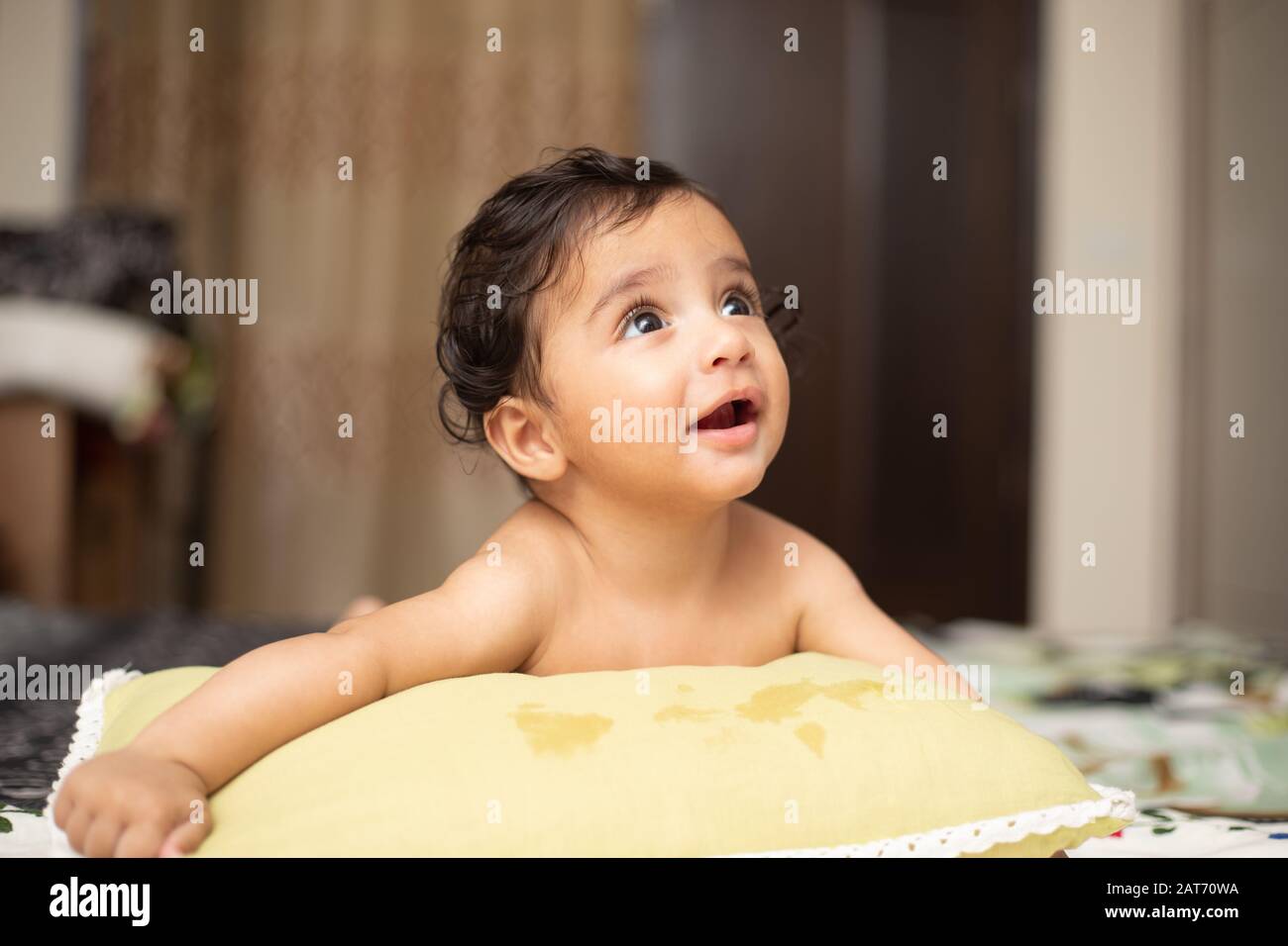 Porträt des Sechs Monate alten indischen Kleinkindes Mit Lächeln und Spielen mit der Familie im Schlafzimmer mit Tageslicht Stockfoto