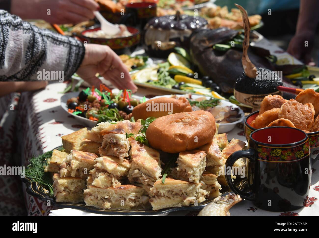 Russischer Kuchen auf dem Tisch mit verschiedenen Fischgerichten geschnitten Stockfoto