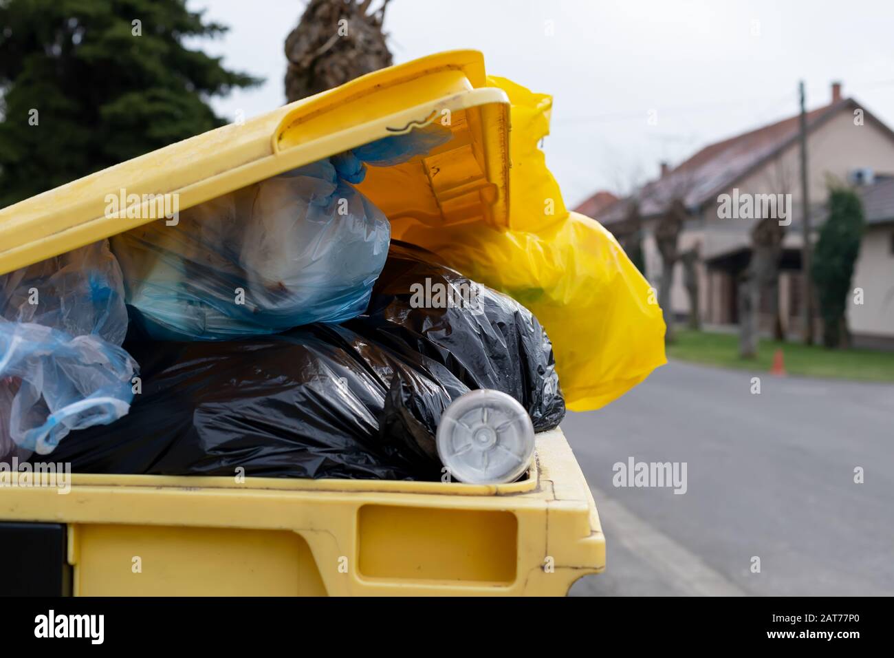 Überfüllte Müllcontainer voll mit gemischtem Müll auf einer Straße Stockfoto