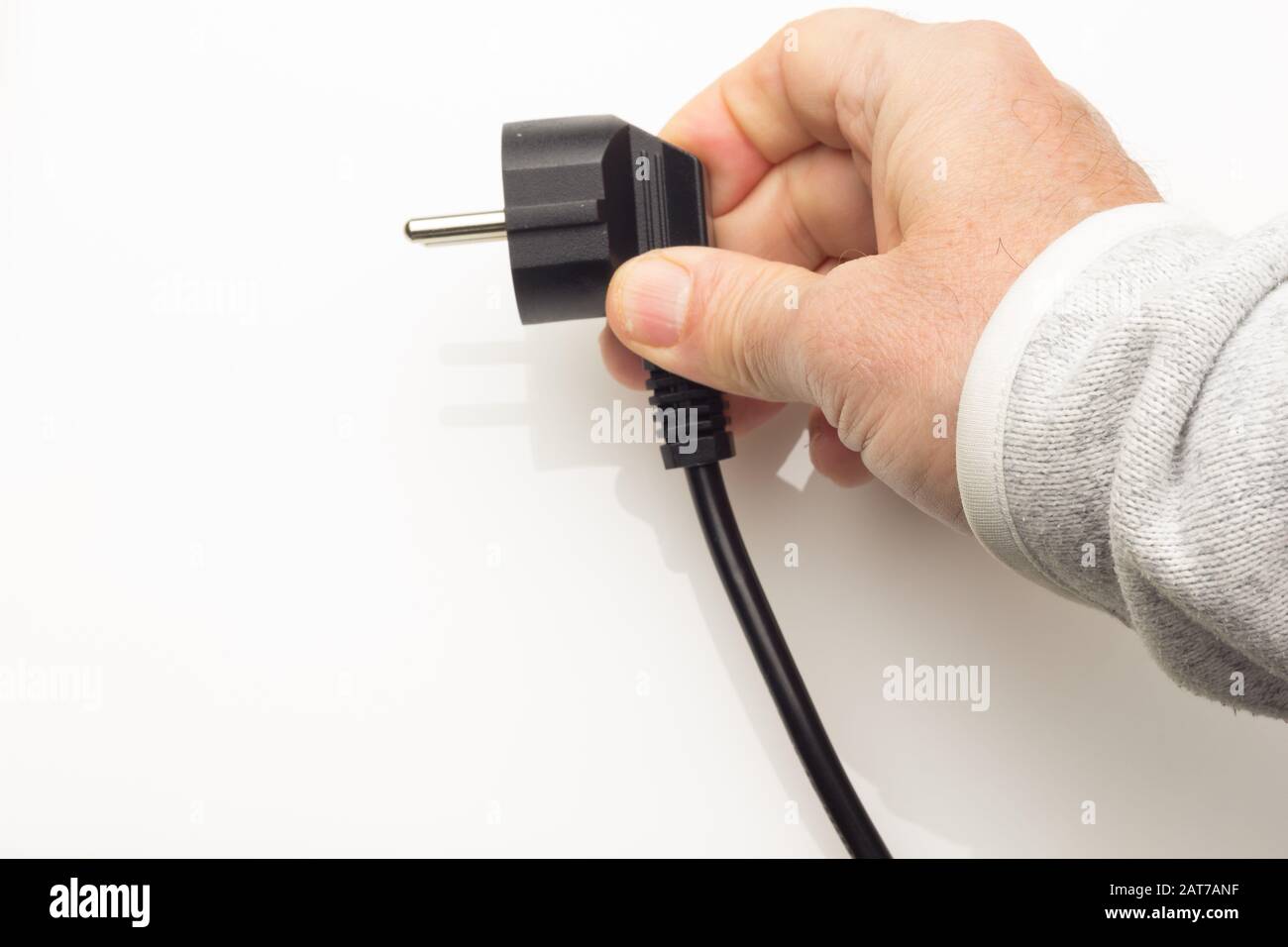 Kabel mit Elektrostecker, der in den elektrischen Strom einstecken kann und  ein Gerät funktioniert; stecken Sie die Hand eines Erwachsenen ein; Stecker  für Zuhause in Europa Stockfotografie - Alamy
