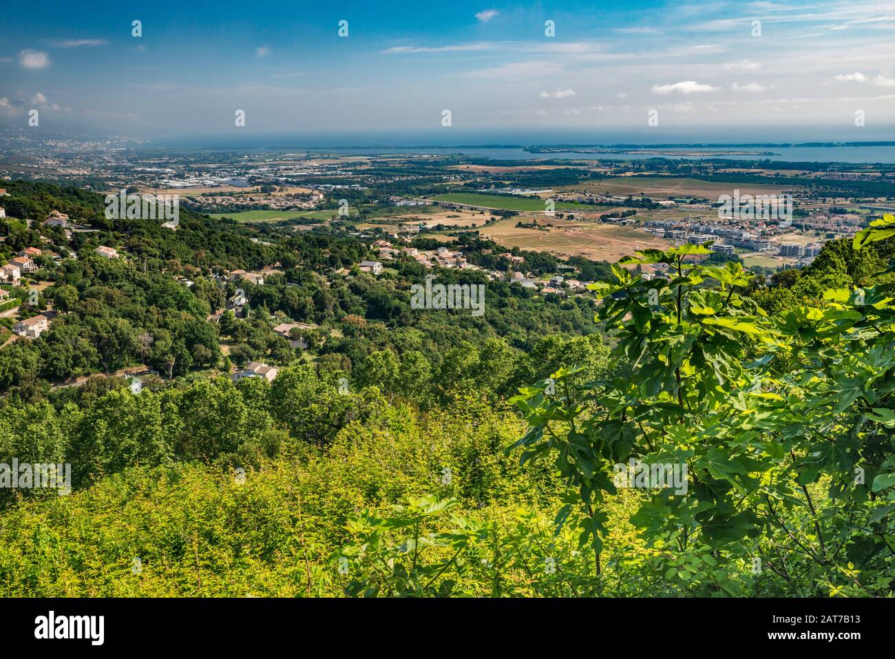 Küstenebene, Biguglia Lake, Stadt Bastia über dem Tyrrhenischen Meer, in Dunst gesehen, weit entfernt von der Hügelstadt Borgo, der französischen Küste von Ober-Corse, Korsika Stockfoto