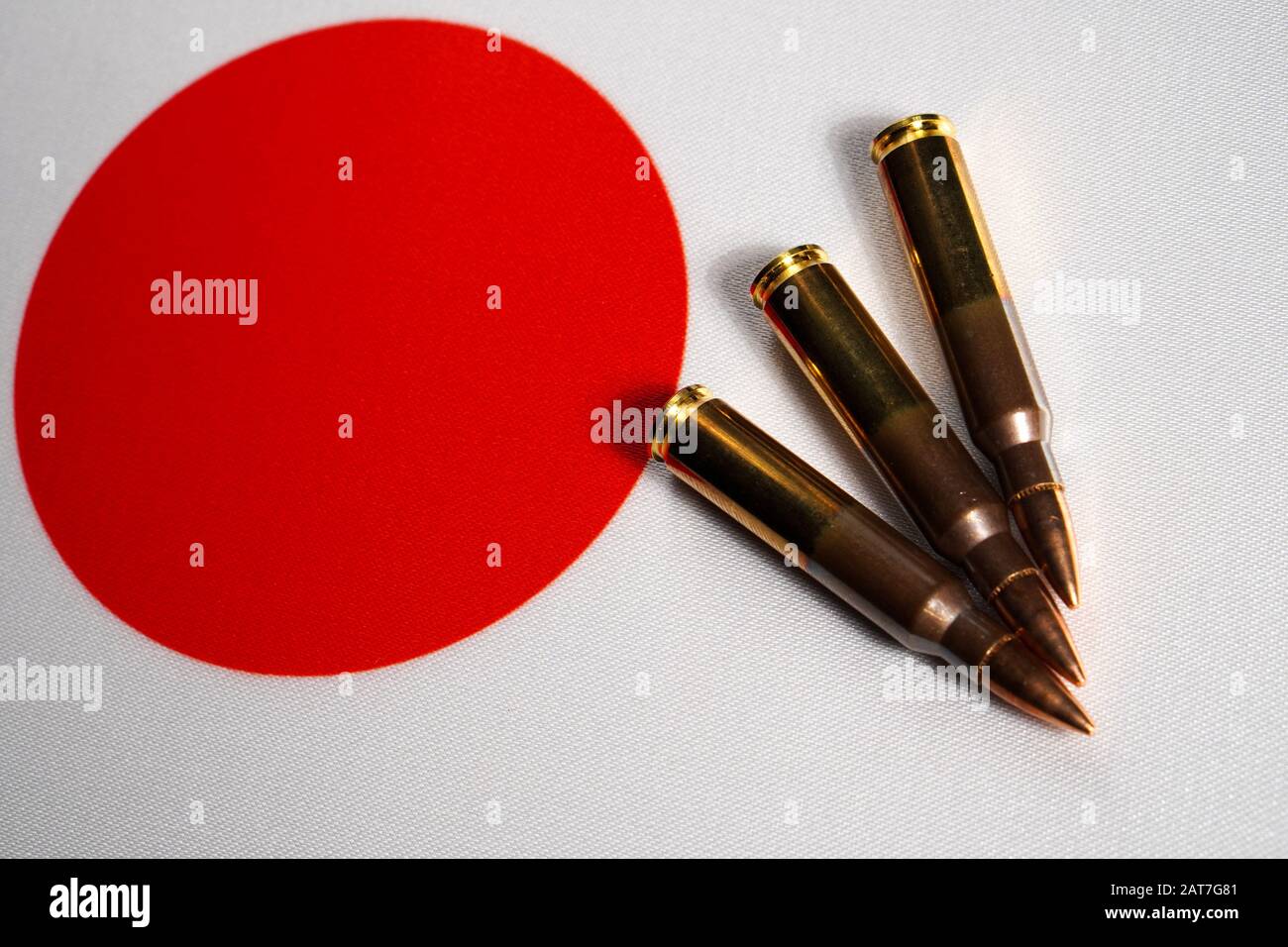 Drei Gewehrpatronen auf der Flagge Japans. Nahaufnahme, Kopierbereich Stockfoto