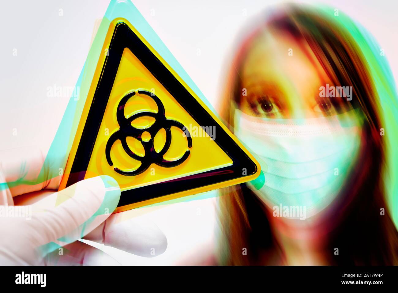 Hand, die ein biologisches Gefahrzeichen vor der Frau mit Gesichtsmaske und einem Coronavirus-Ausbruch hält Stockfoto