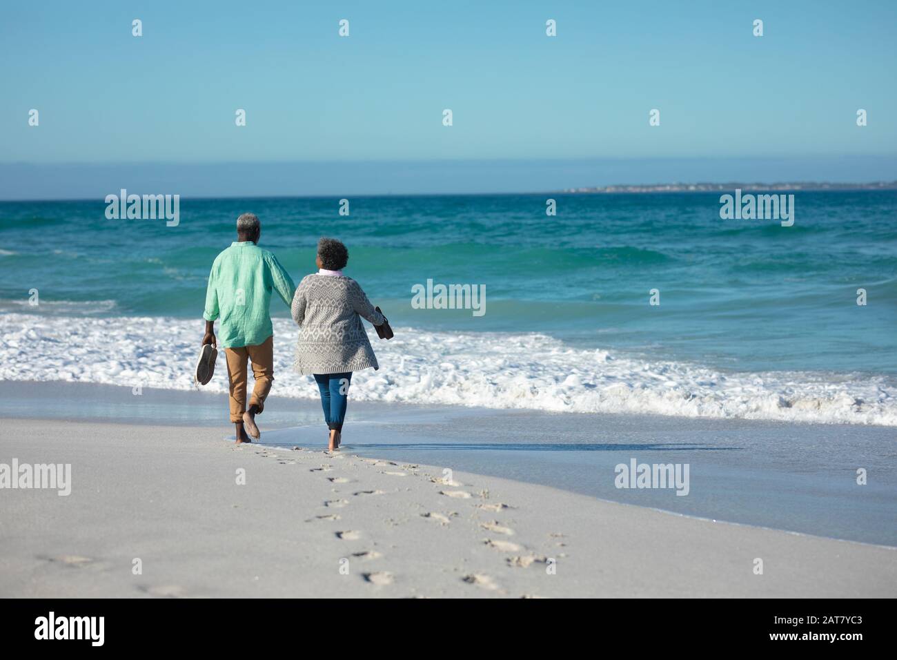 Altes Paar, das am Strand spazieren geht Stockfoto