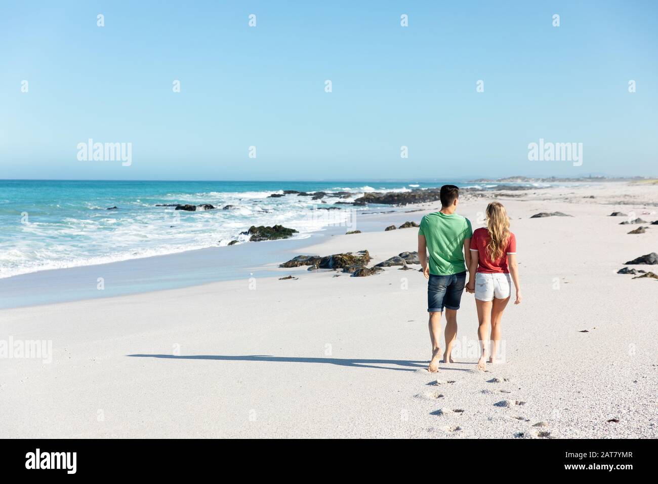 Rückblick junge Paare laufen am Strand Stockfoto