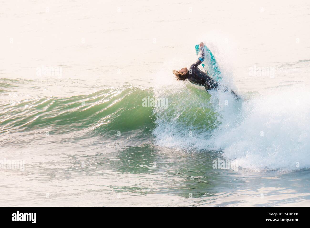 Surfer, die eine Welle in Porthleven, Cornwall, im Oktober 2019 fangen Stockfoto
