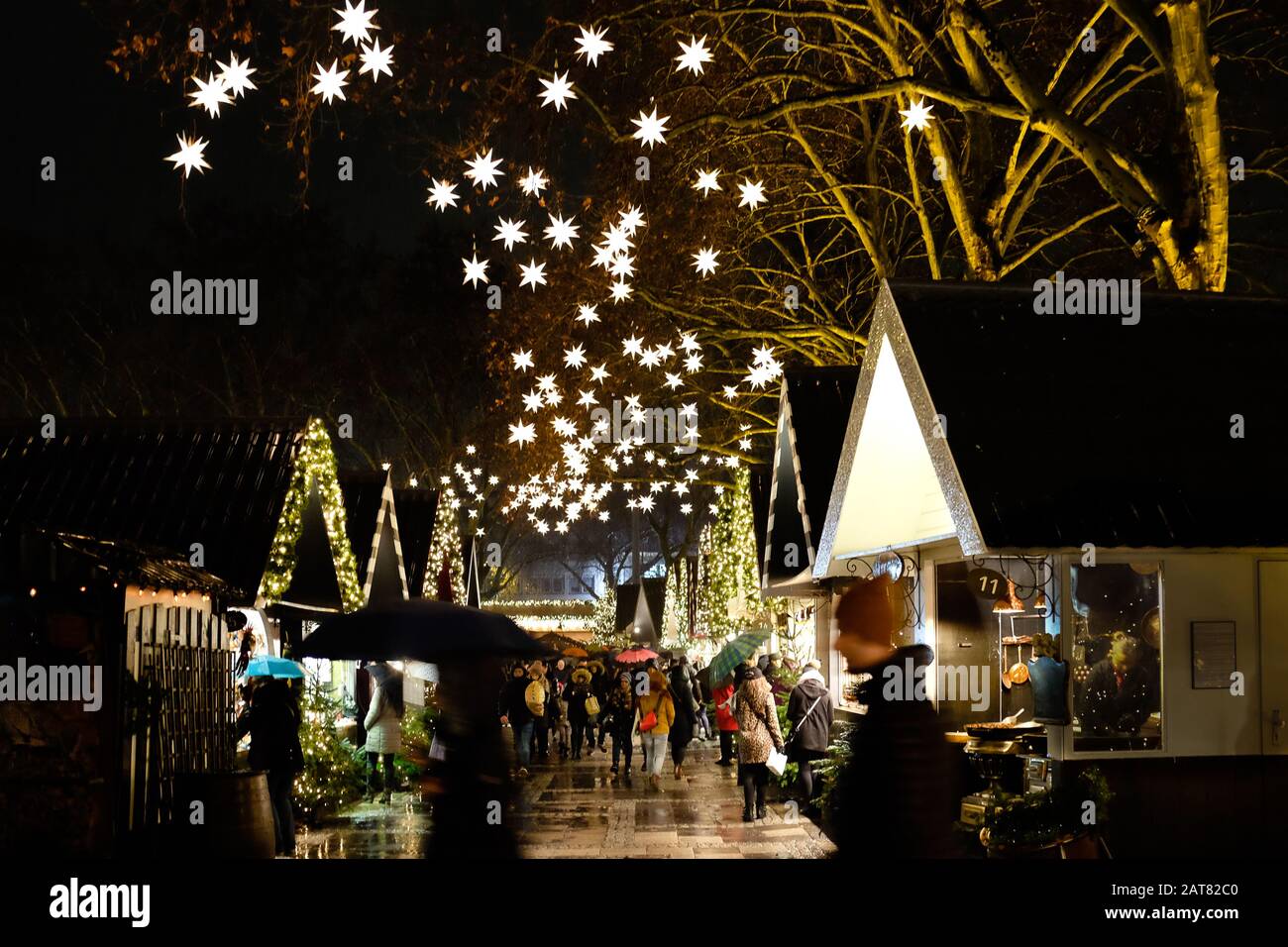 Deutscher Weihnachtsmarkt in der Nacht mit Marktständen und beleuchteten Sternen Stockfoto