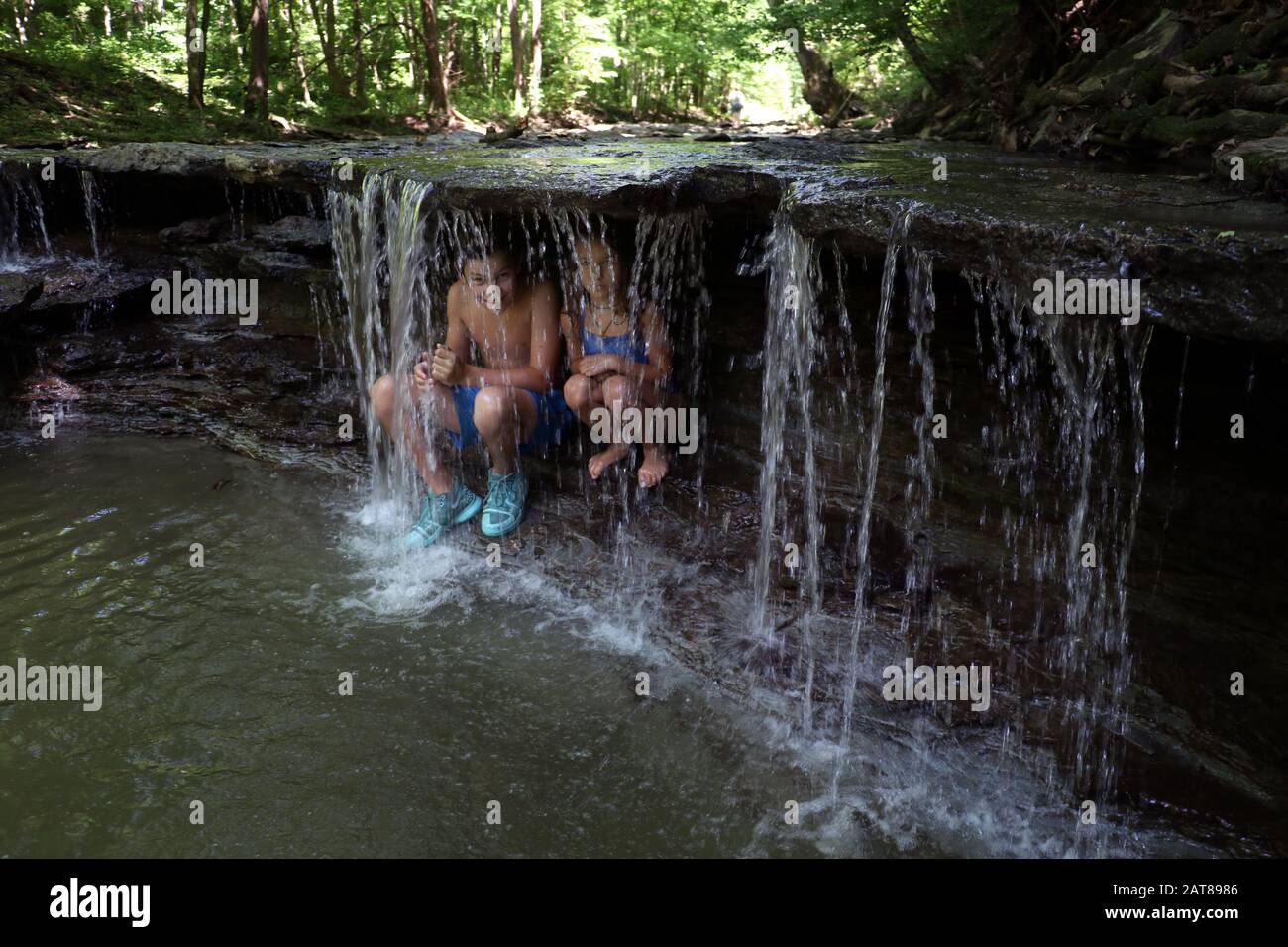 Familienkinder, die im Wasserfall des Bachs, Ohio USA, spielen Stockfoto