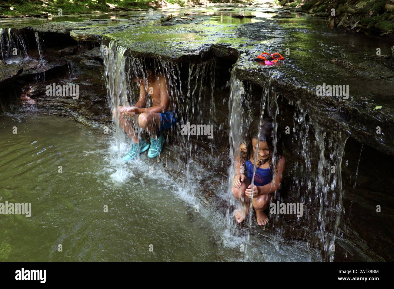 Familienkinder, die im Wasserfall des Bachs, Ohio USA, spielen Stockfoto