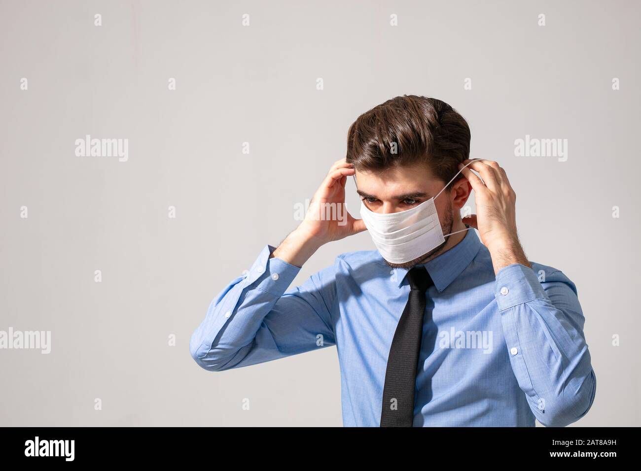 Ist Zeit zum Schutz der ganzen Zeit: Eleganter Mann, der einen Mundschutz trägt, um zu verhindern, dass er bei der Arbeit oder auf dem Weg zur Arbeit krank wird Stockfoto