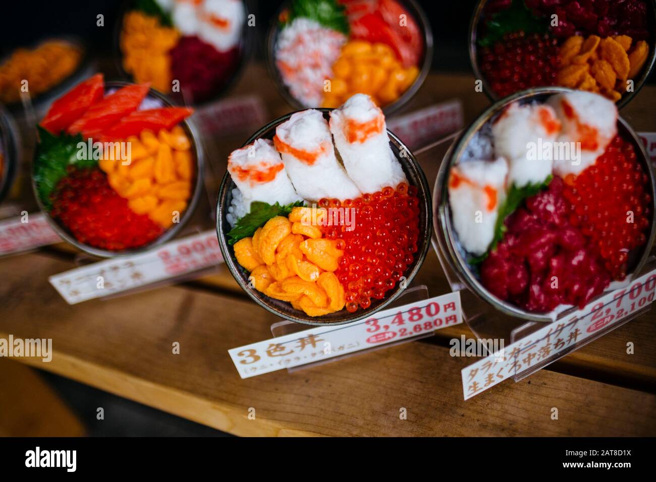 Große Nähe zu Plastikschüsseln japanischer Speisen, die außerhalb eines Restaurants ausgestellt werden. Stockfoto