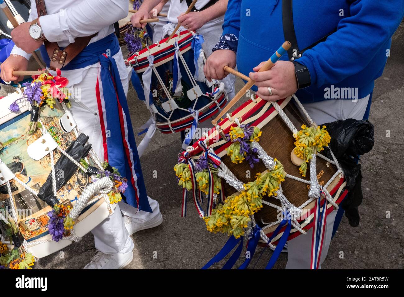 Trommler, die Trommeln spielen und blaue Bänder mit Blumen tragen, Obby Oss Procession, Padstow, Cornwall, Großbritannien Stockfoto