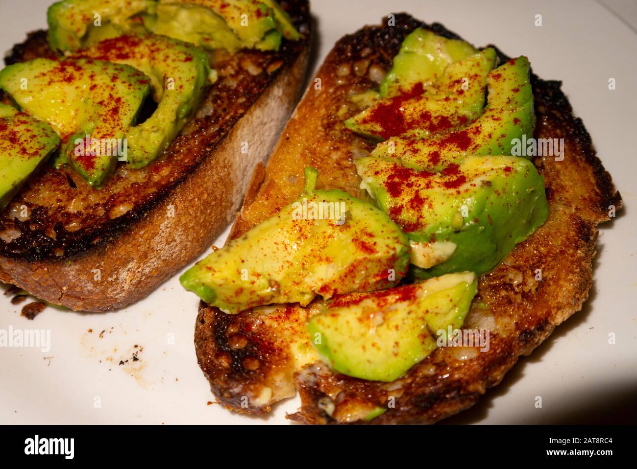 Avocado garniert mit Paprika auf gebuttertem Toast aus nächster Nähe Stockfoto