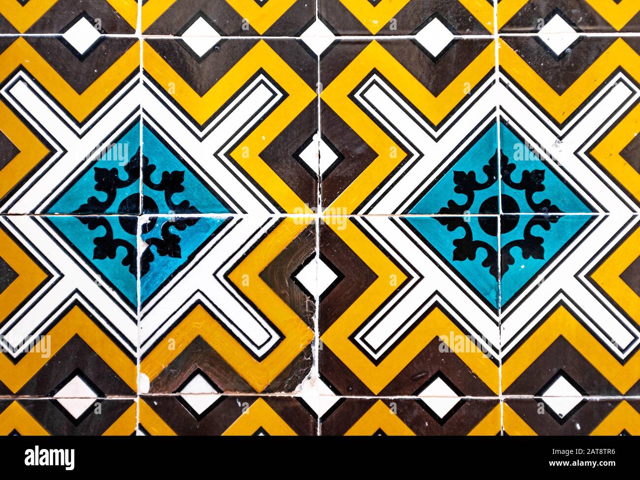 Bunte portugiesische, traditionelle Fliesen Azulejos mit blauem, orangefarbenem, braunem und weißem geometrischem Muster. Stockfoto