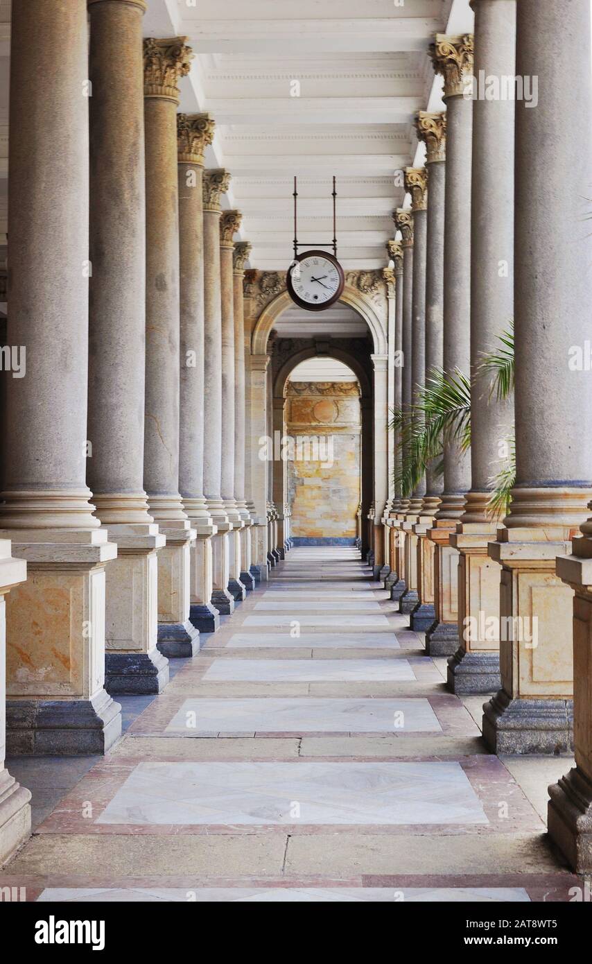 Korridor in der Mill Colonnade. Uhr an der Decke hängen, grüne Palmblätter, gewölbte Tür. Karlsbad, Republik Chezh Stockfoto