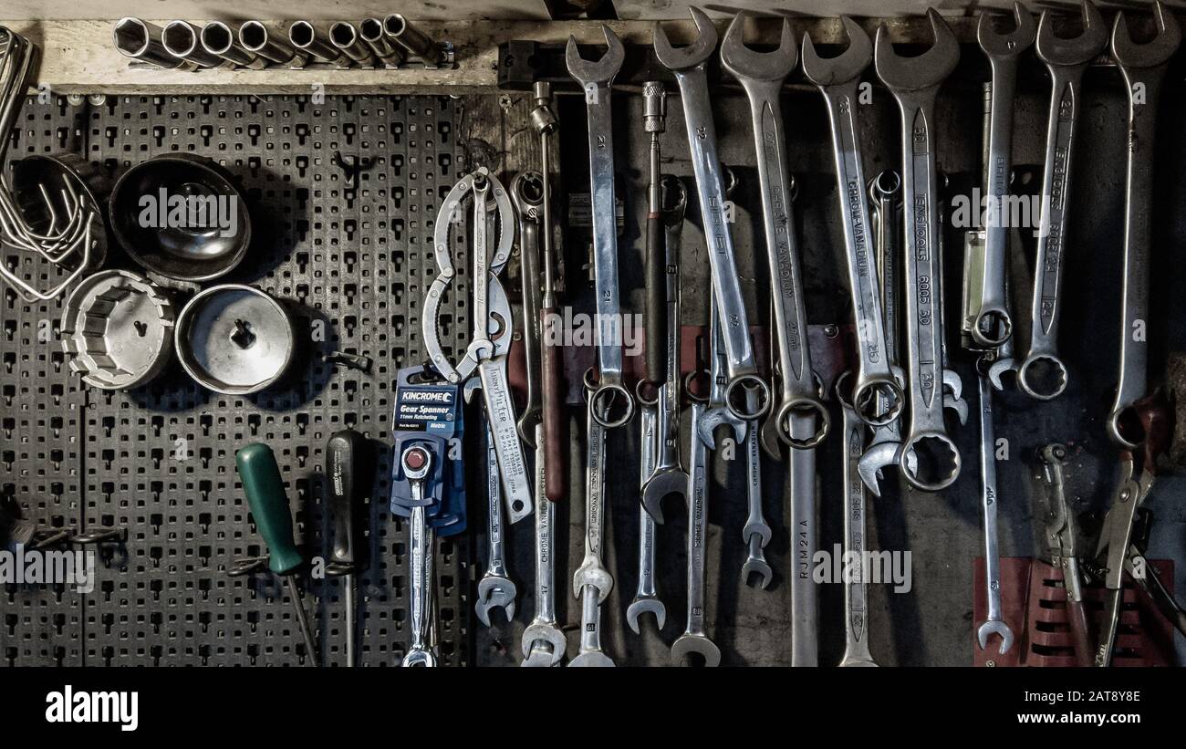 London, England - 13. November 2019: Schraubenschlüssel, Schraubenschlüssel und Schraubendreher an der Wand einer Kfz-Mechaniker-Garage Stockfoto