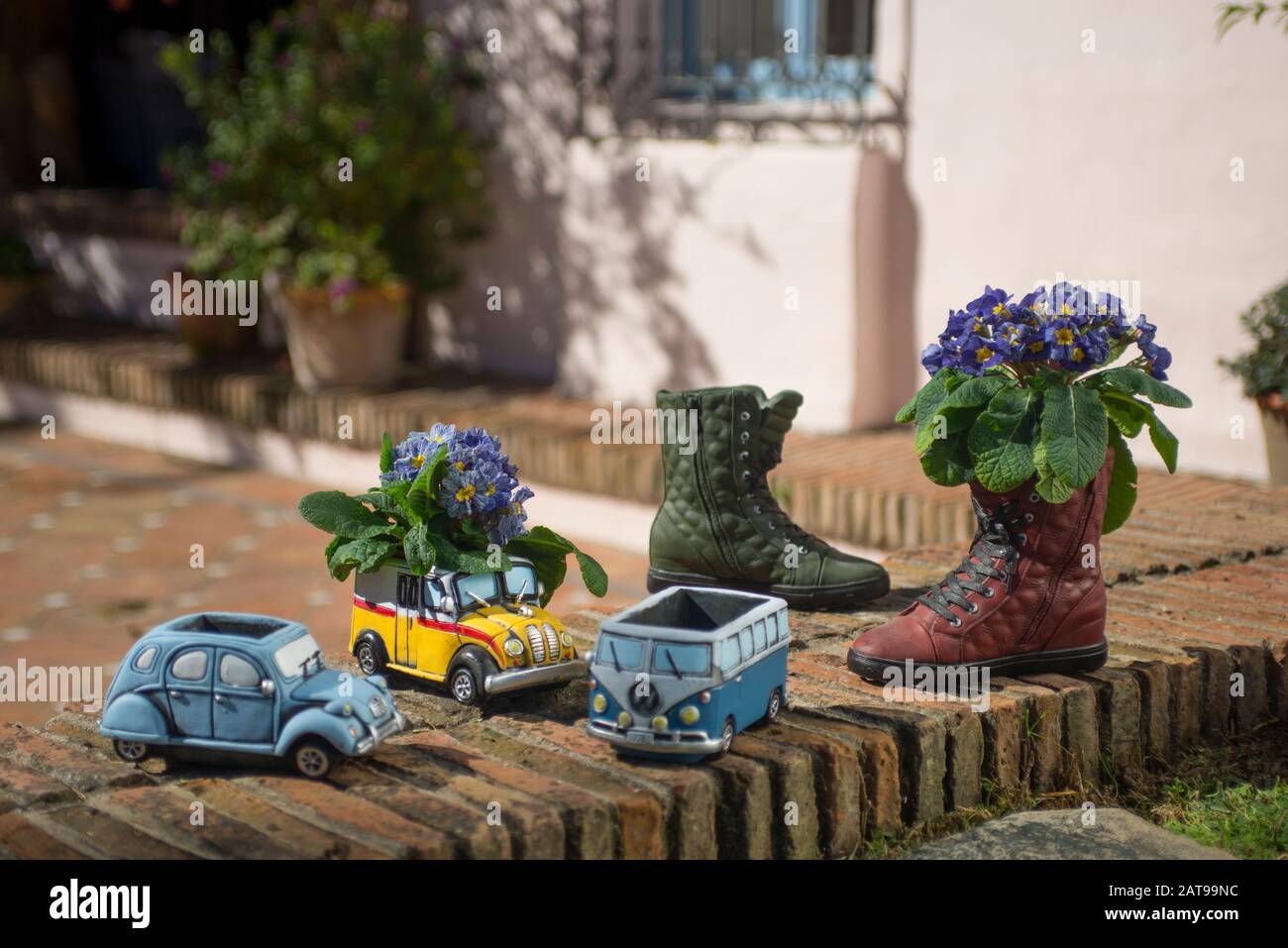Winzige Töpfer-Blumentopf-Ständer, die wie Oldtimer und Stiefel geformt sind. Stockfoto