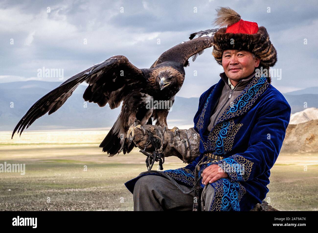 Eagle Hunter mit seinem goldenen Adler in Bayan Olgii, West Mongolia. Stockfoto