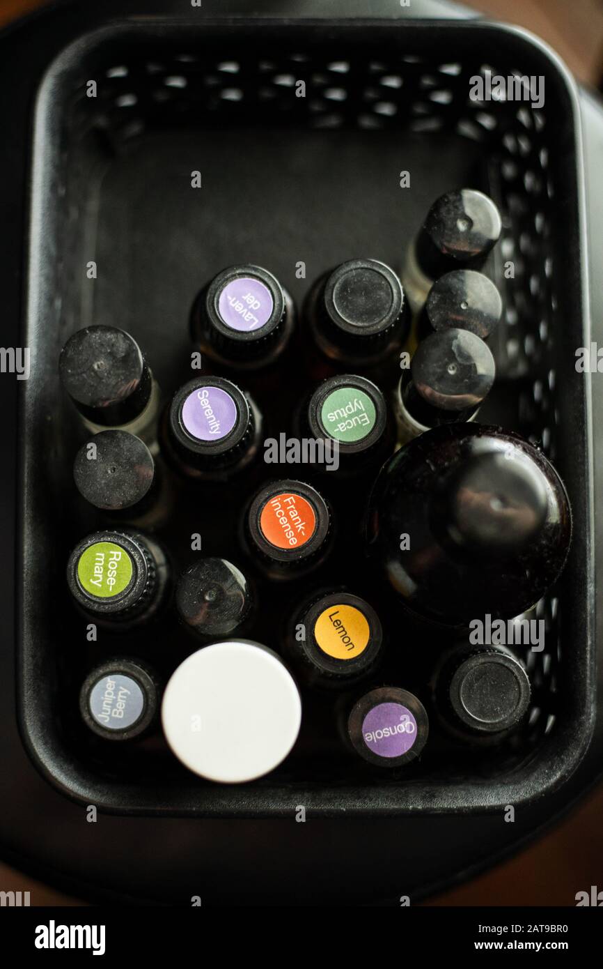 Schließen Sie die Deckel der schwarzen und weißen Glasflaschen mit ätherischen Ölen, die in einem schwarzen Behälter gekennzeichnet sind, auf Stockfoto