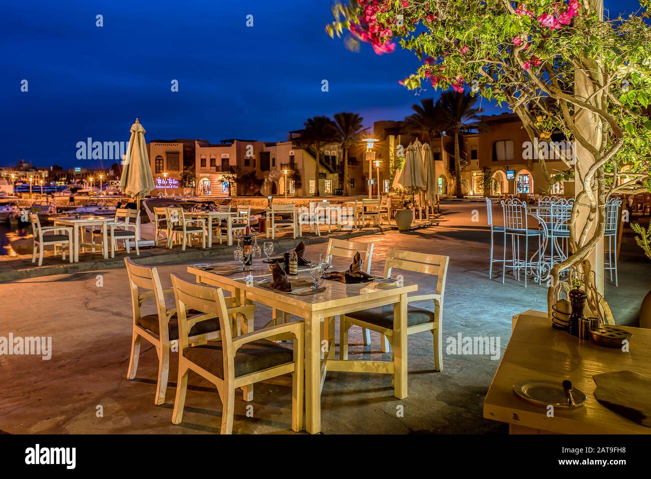 Tisch mit vier Stühlen und braunen Servietten am Abend bei Sonnenuntergang auf dem Seaside Walk, Abu tig, el Gouna, Ägypten, 14. Januar 2020 Stockfoto