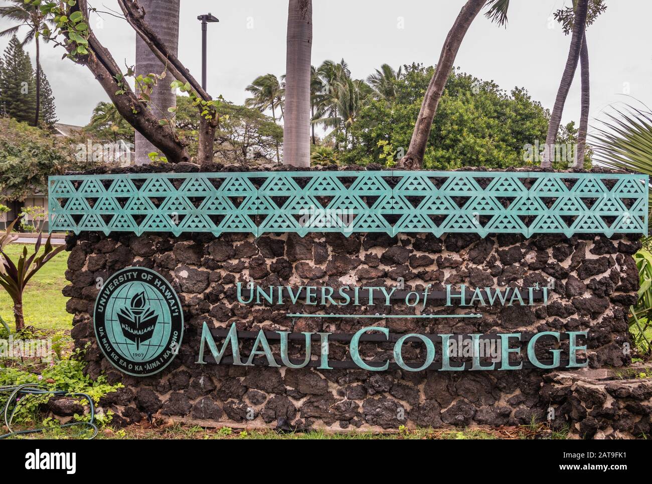 Kahului, Maui, Hawaii, USA. - 12. Januar 2020: Englisches Sprachzeichen für die University of Hawaii, Maui College Campus, in grüner Laub und Blume Stockfoto