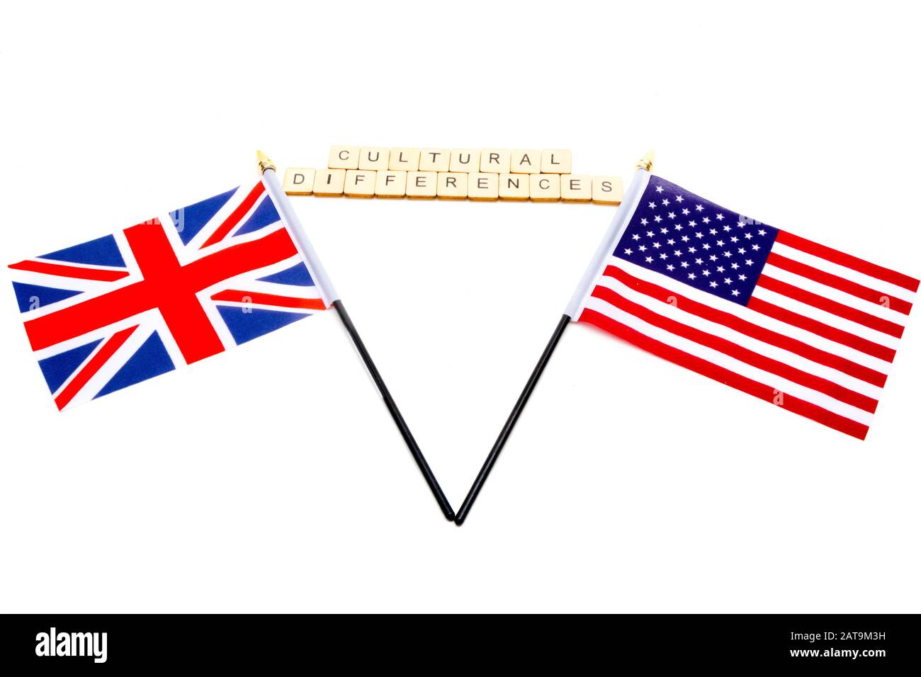 Die Flaggen des Vereinigten Königreichs und der Vereinigten Staaten isolierten sich auf einem weißen Hintergrund mit einem Zeichen, das kulturelle Unterschiede liest Stockfoto