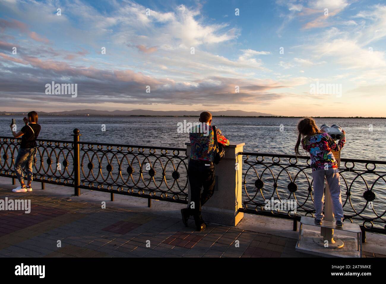 Menschen, die sich bei Sonnenuntergang am Flussufer des Amur entspannen Stockfoto