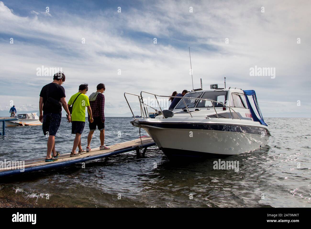 Touristen und Boote am Baikalseeufer in Listvyanka Stockfoto