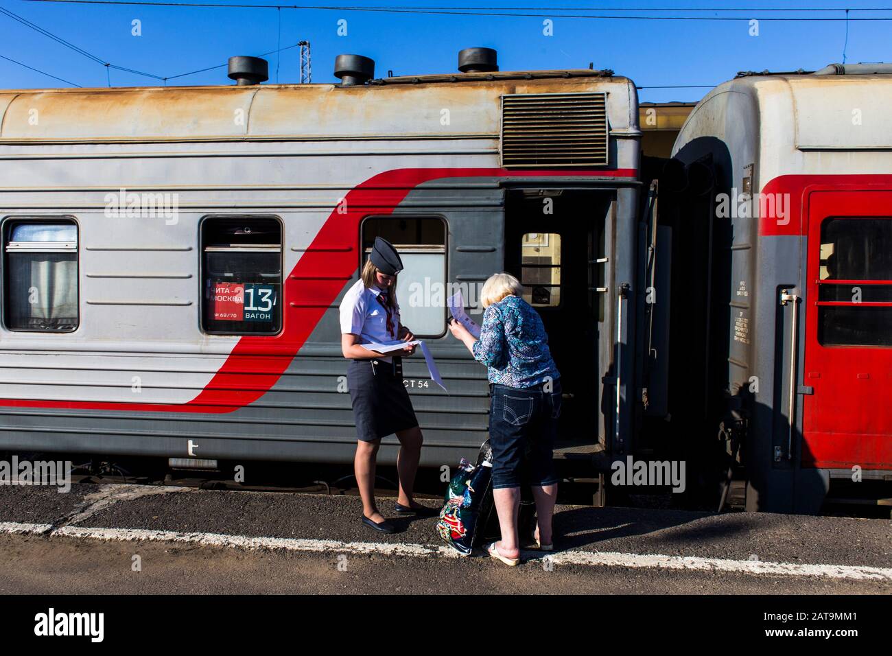 Provodnitsa (Zugbegleiter), die eine Fahrkarte des Passagiers auf dem transsibirischen Express in Jaroslawl kontrolliert Stockfoto
