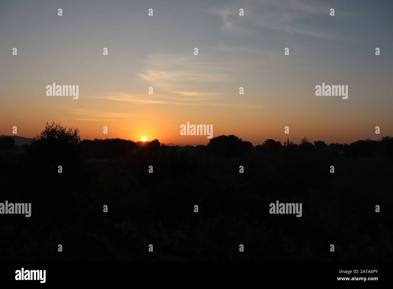 Foto im Querformat von Silhouette bei Sonnenaufgang mit Sonne Stockfoto