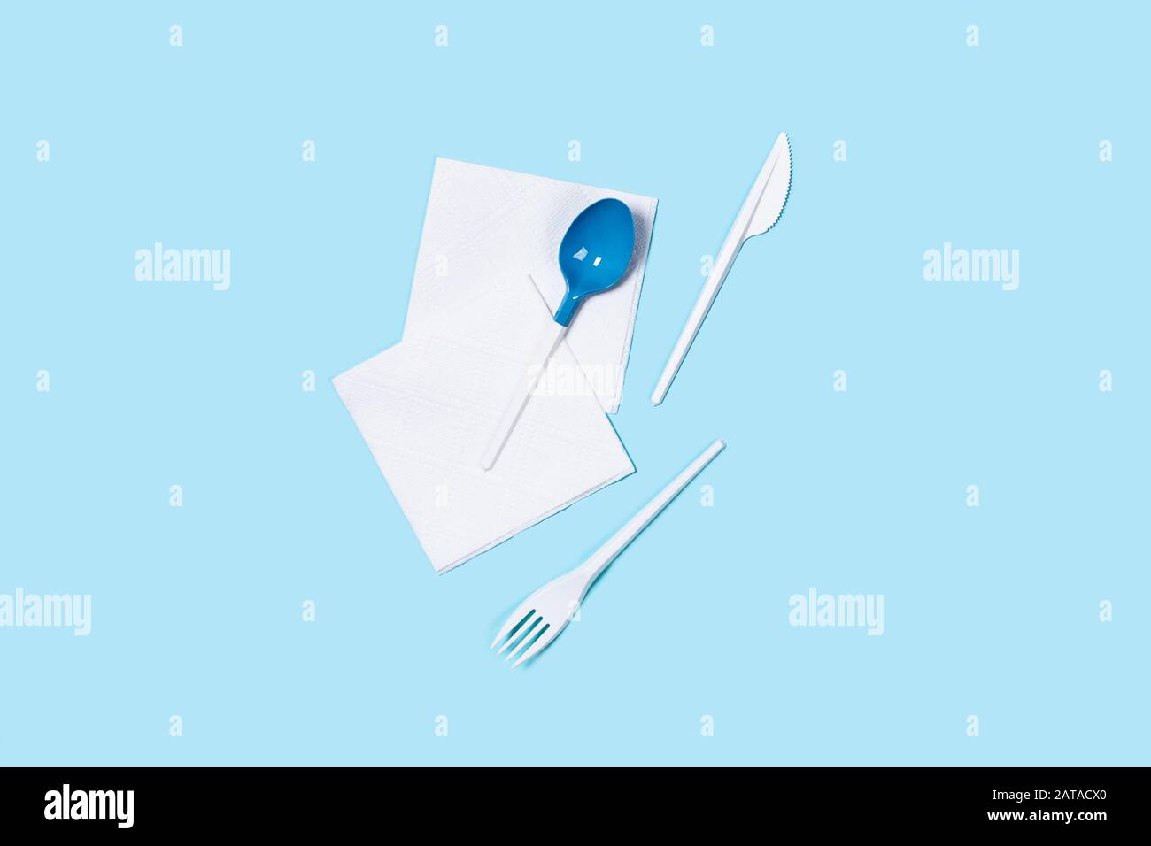 Abbildung der weißen Kunststofflöffel auf blauem Hintergrund. Flaches Layout, Draufsicht, Kopierbereich. Stockfoto