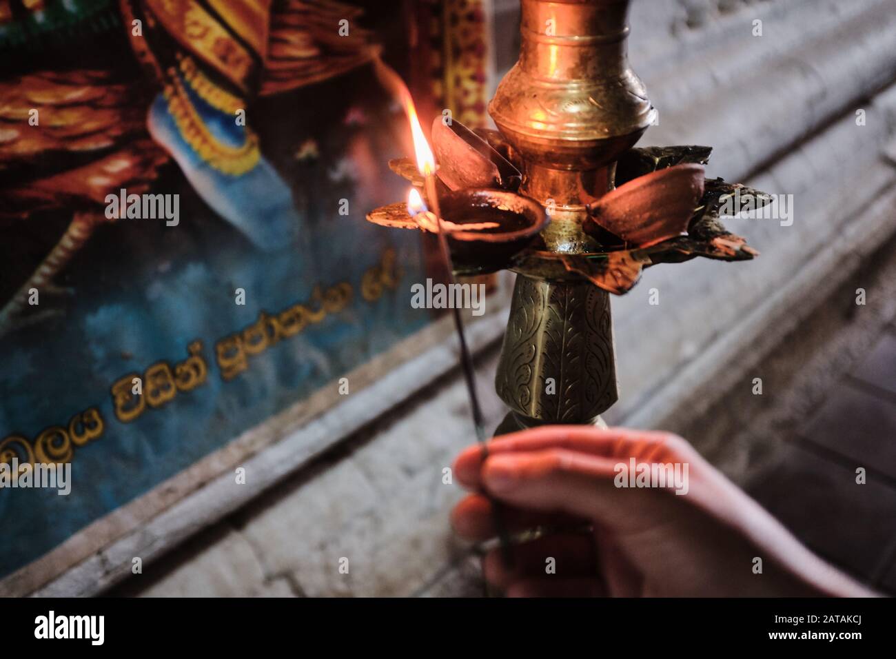 Beleuchtung einer Kerze in einem buddhistischen Tempel in Sri Lanka Stockfoto