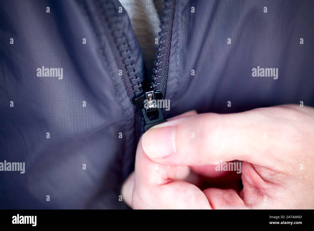 Person mit Reißverschluss an der Jacke. Nahaufnahme Stockfoto