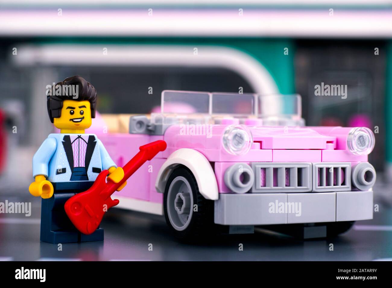 Tambov, Russische Föderation - 22. Januar 2020 Lego Rosa 1950er-Stil Cabrio und Rock n Roll Star Minifigure mit Gitarre in der Nähe. Studio gedreht. Stockfoto
