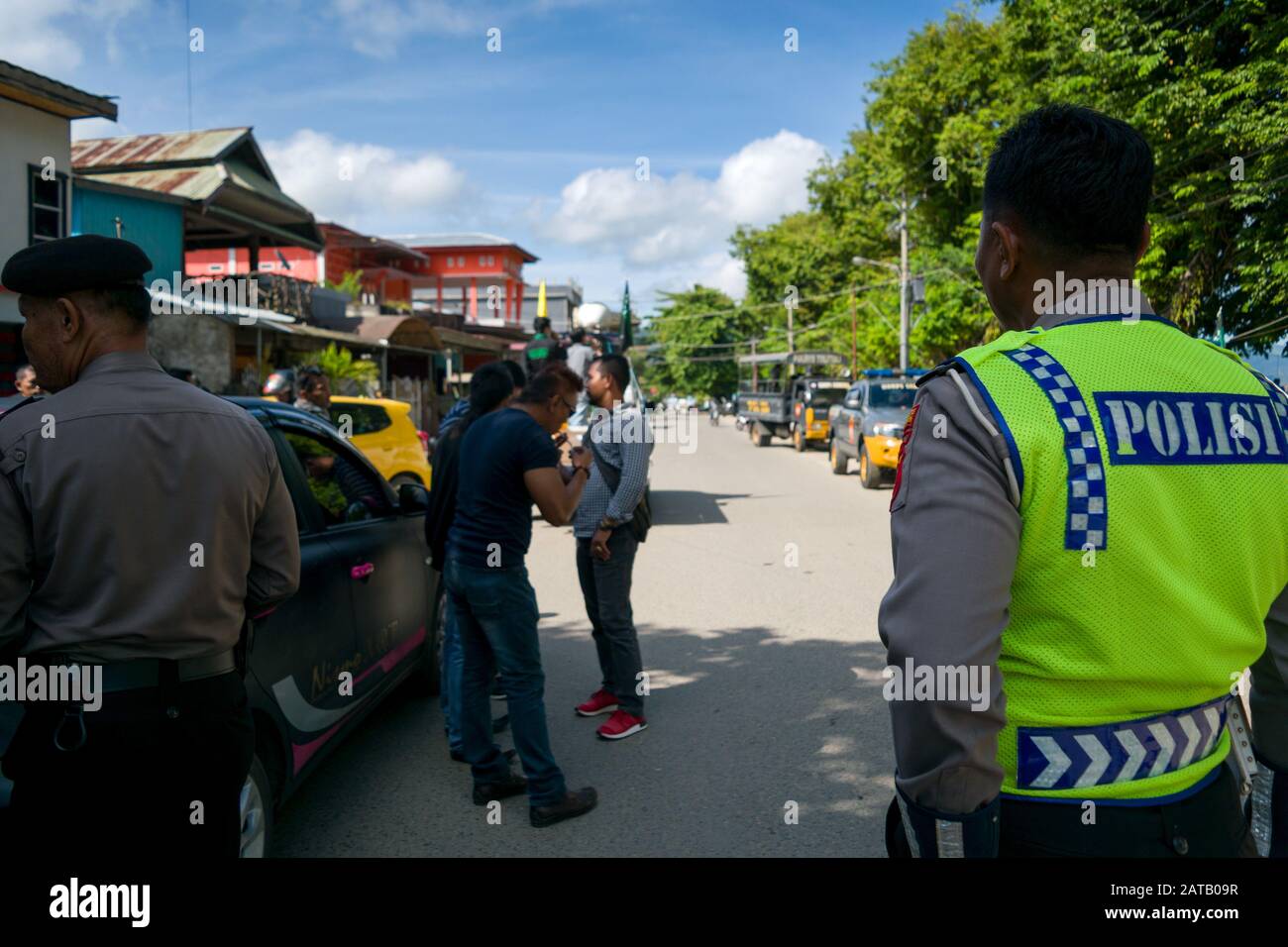 Indonesische Verkehrspolizei von seinem Rücken. Die indonesische Polizei steht am Straßenrand, um sich mit der Demonstration zu befassen, die stattfinden wird. Stockfoto