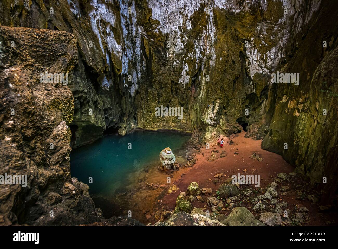 Einheimische in einer Brackwasserhöhle auf der Panasia-Insel, Papua-Neuguinea. Am Fuß der Höhle vermischt sich Meerwasser mit frischem Regenwasser, das als Trinkwasser in einem Tank gesammelt wird Stockfoto