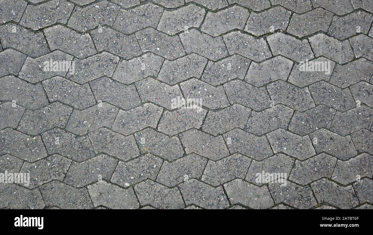 Grau strukturiertes Pflaster mit Zick-Zack-Muster. Gefunden auf einer Straße in Malmö, Schweden. Stockfoto