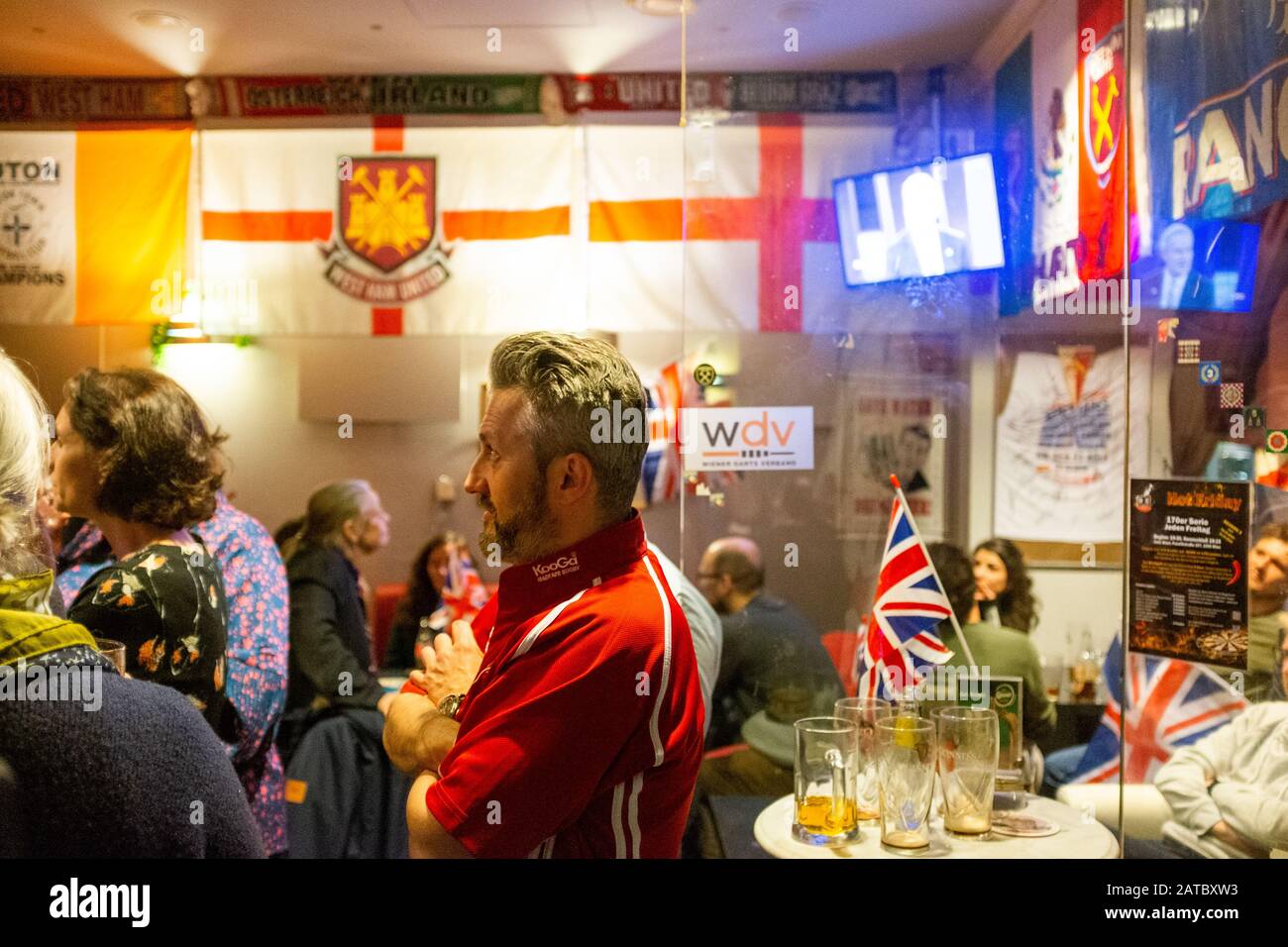 Ein Mann liest sein Handy, während sich die Europäer zum Gedenken an die Brexit Night, den letzten Tag der UKs in der EU, in einer britischen Kneipe am 31. Januar in Wien, Österreich versammeln Stockfoto
