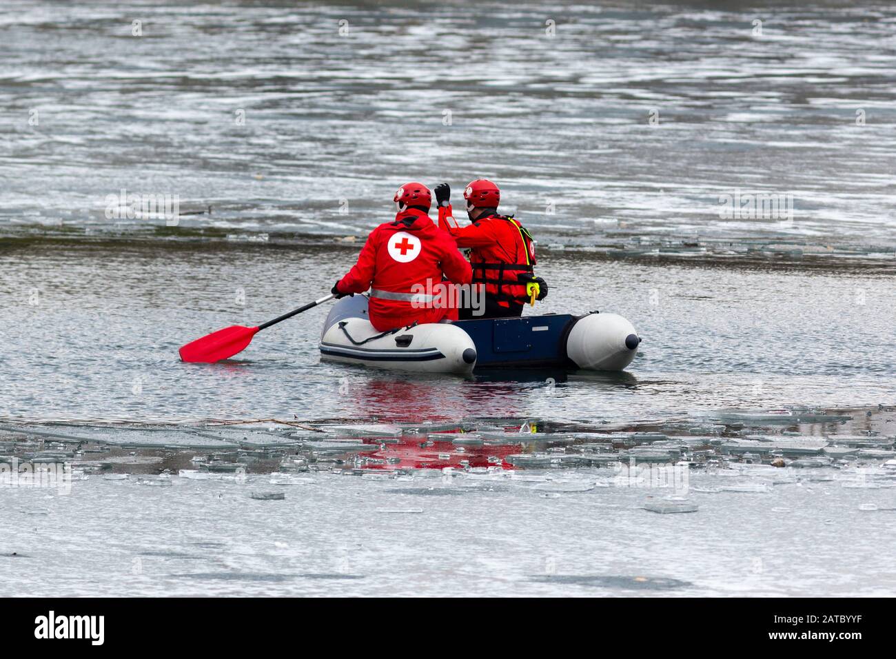 Freiwillige des bulgarischen Roten Kreuzes sind in einem Boot zu sehen, bevor ein traditionelles Epiphanienkreuz in einen eisigen See geworfen wird. Stockfoto