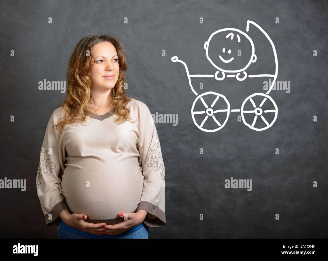 Schwangere stellt sich ein zukünftiges Kind im Kinderwagen vor Stockfoto
