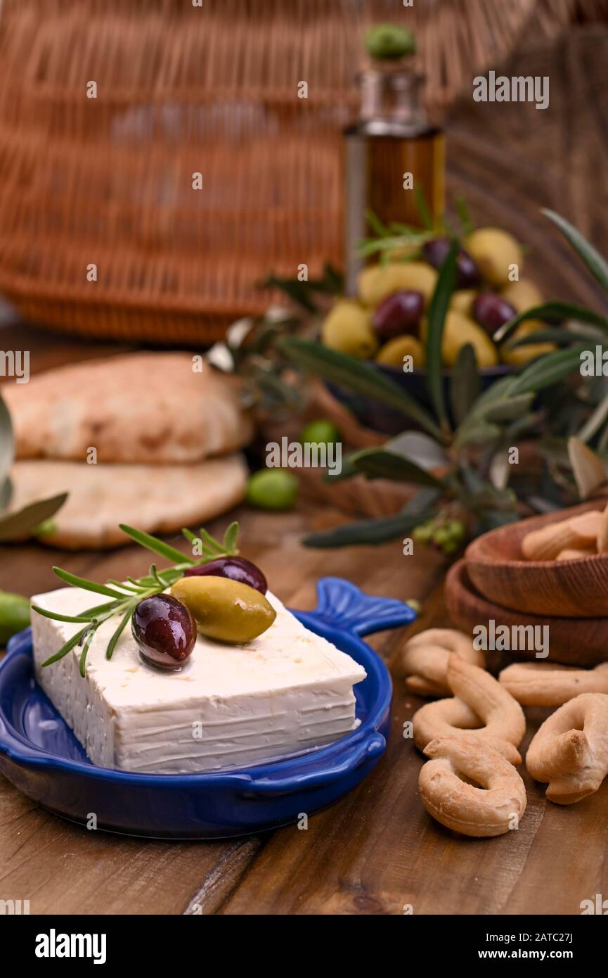 Griechische Fetakäse und Oliven verschiedener Sorten. Traditionelles Brot und Krokodile auf Holzgrund. Kopierbereich Stockfoto