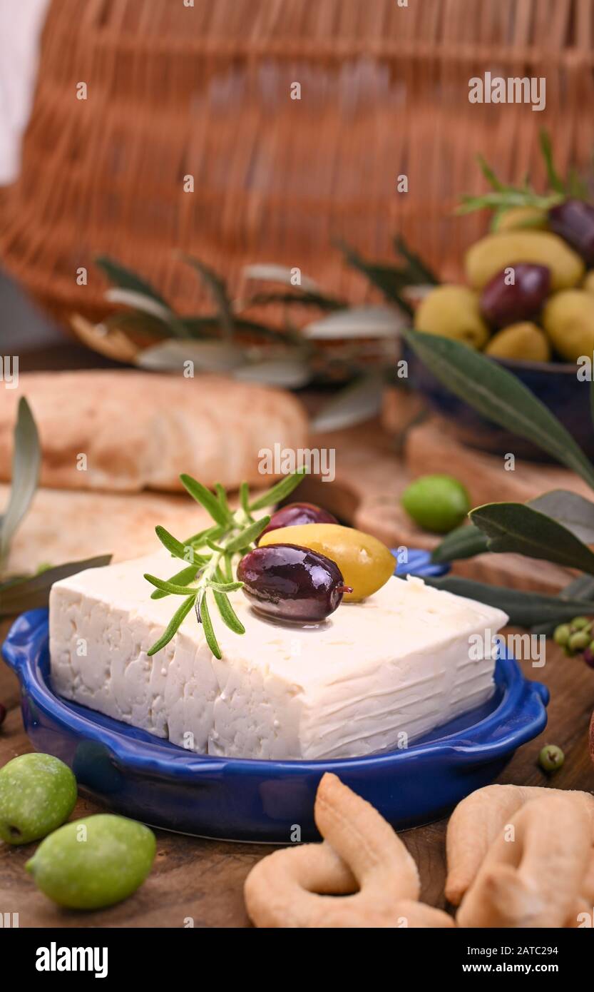 Griechische Fetakäse und Oliven verschiedener Sorten. Traditionelles Brot und Krokodile auf Holzgrund. Kopierbereich Stockfoto