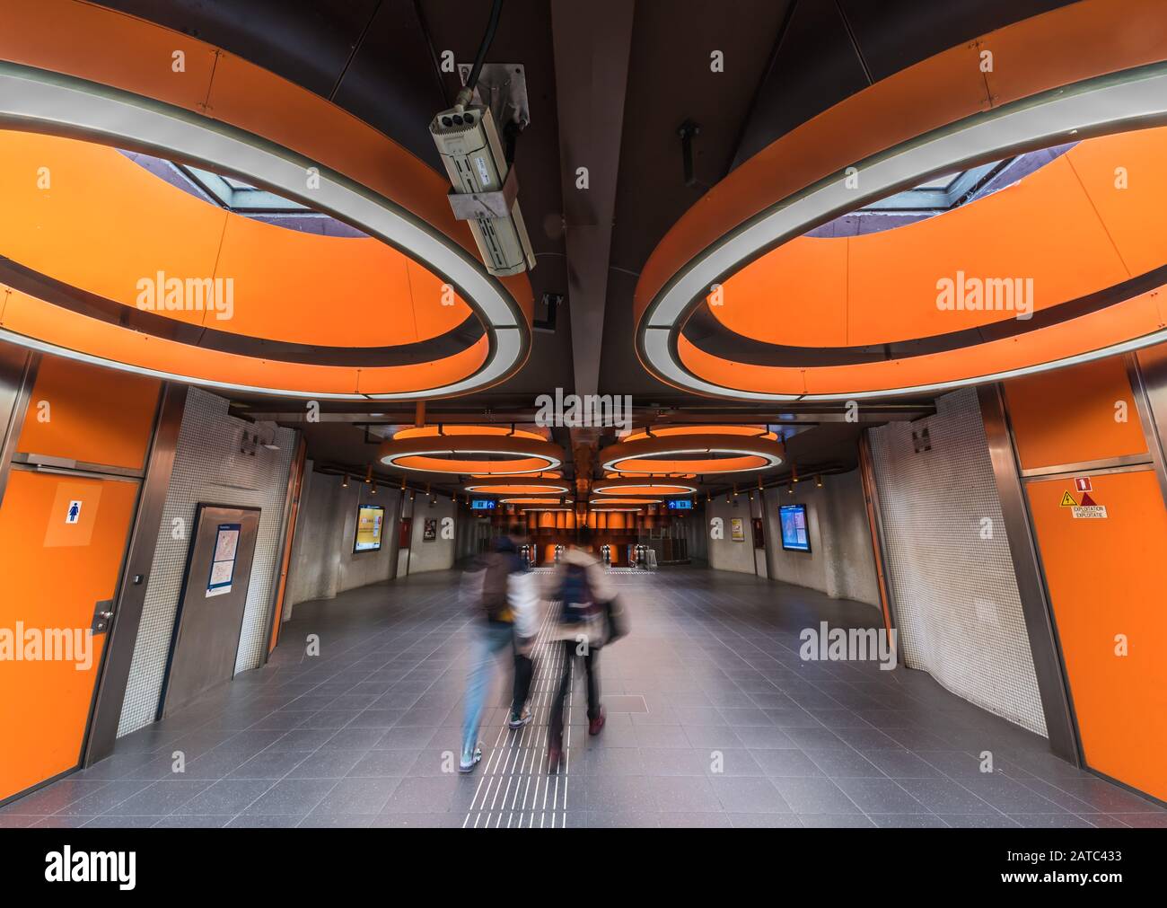 Laeken, Region Brüssel-Hauptstadt / Belgien - 09 25 2019: Menschen, die durch die moderne oragn gestaltete Metrostation Pannenhuis spazieren Stockfoto