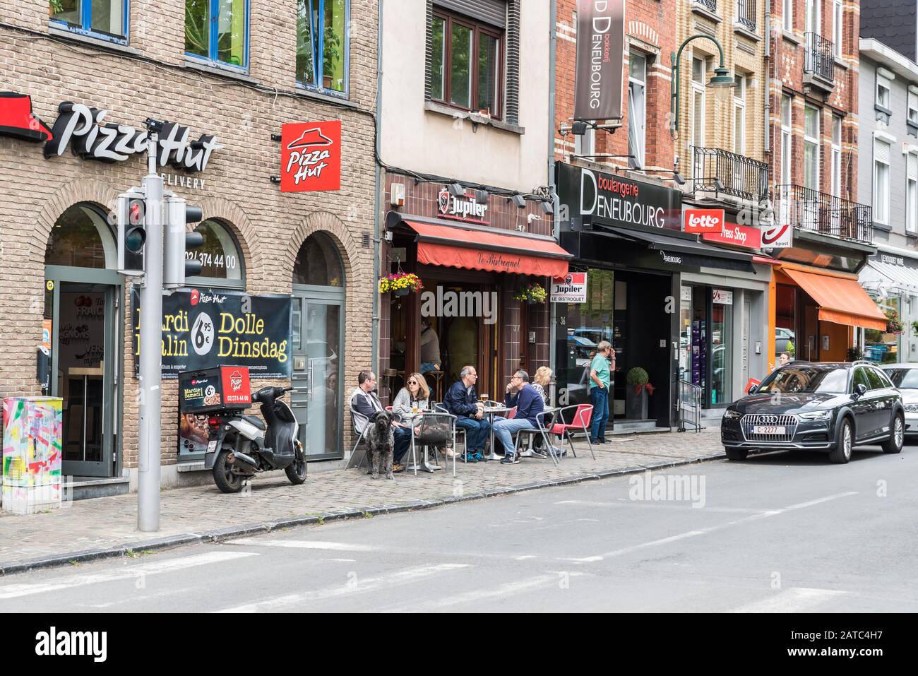 Uccle, Brüssel / Belgien - 06 14 2019: Menschen, die auf sonnigen Terrassen am Stadtplatz Saint Job essen und trinken Stockfoto