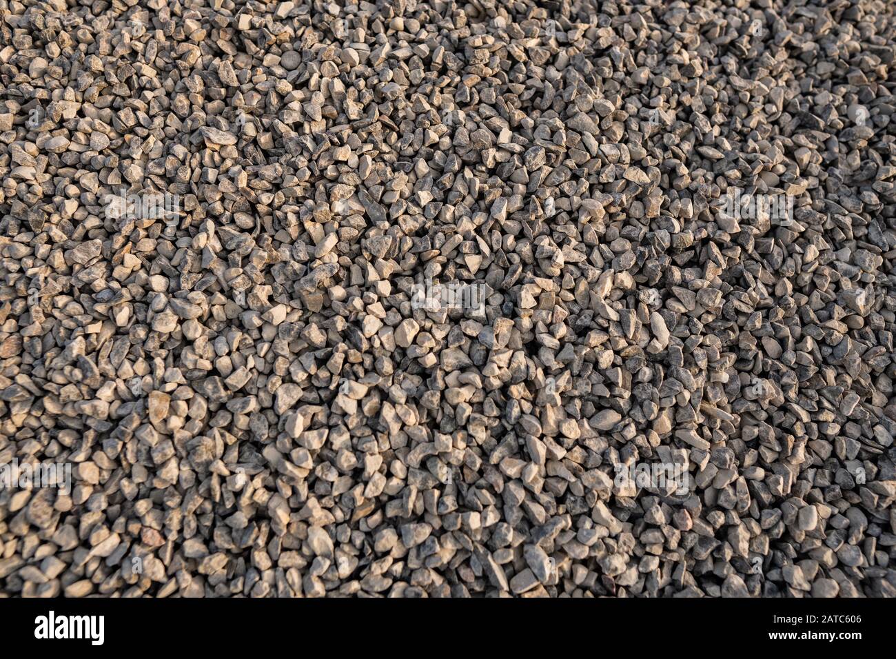 Hintergrund von Meeressteinen, Steingrau unterlegt von vielen kleinen Steinen, Kies Textur. Kleine Steine, kleine Felsen, Kieselsteine in vielen Grautönen, Stockfoto