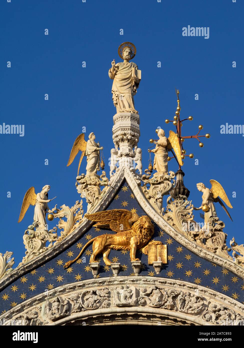 Statue von San Marcos über dem von Venedig geflügelten Löwen an der Fassade der Markusbasilika in Venedig Stockfoto