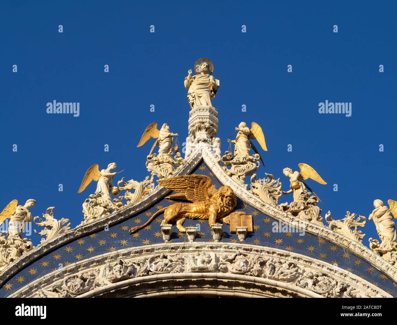 Statue von San Marcos über dem von Venedig geflügelten Löwen an der Fassade der Markusbasilika in Venedig Stockfoto